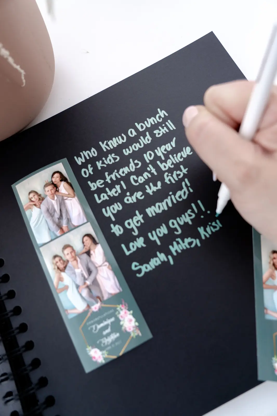 Guest writing a message beside printed photo booth strips